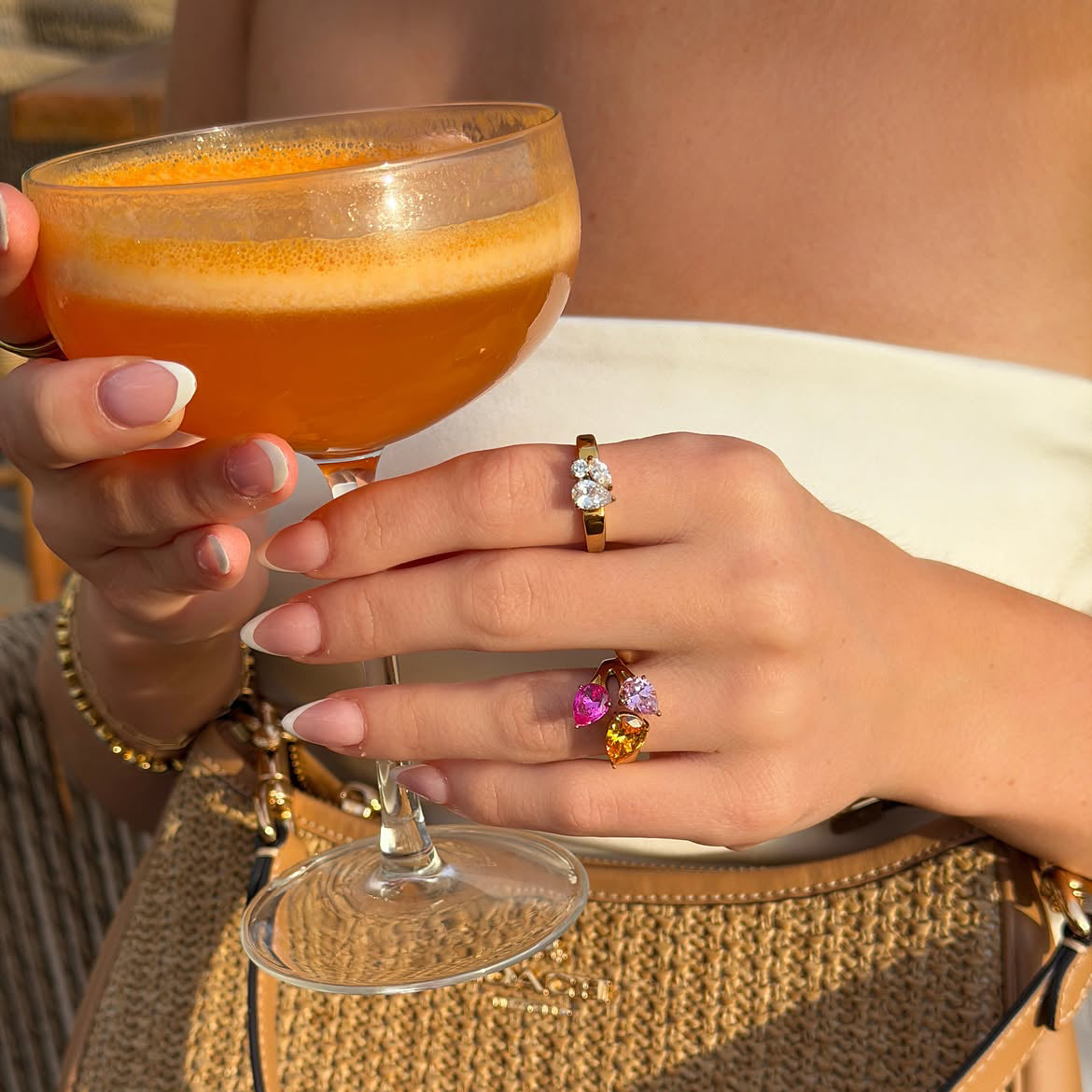 Rings worn with an orange spritz and a straw bag